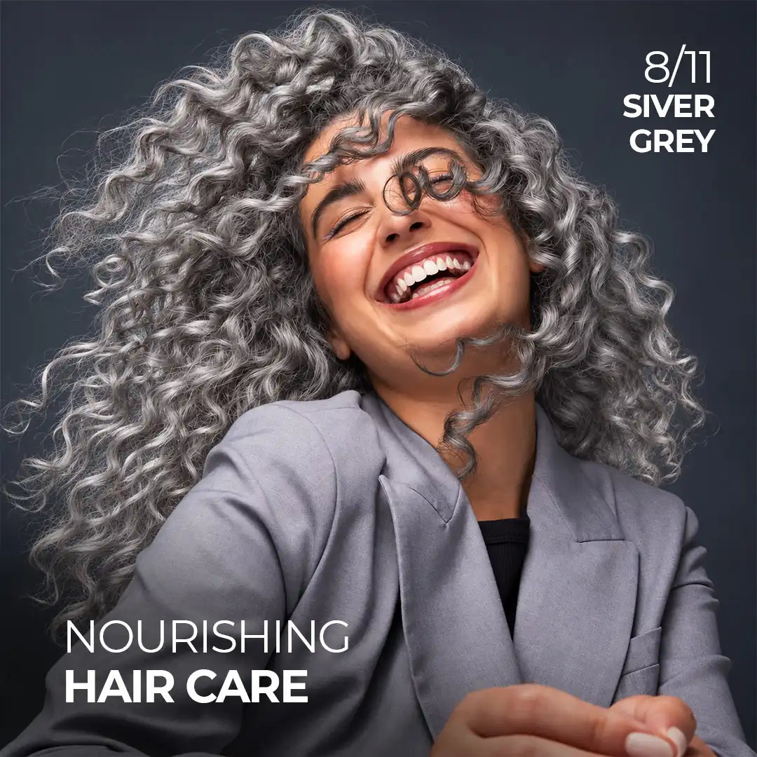 Smiling woman with voluminous, shiny silver grey curly hair showcasing StayMyx 8/11 Silver Grey hair color and a soft, glossy-looking finish.