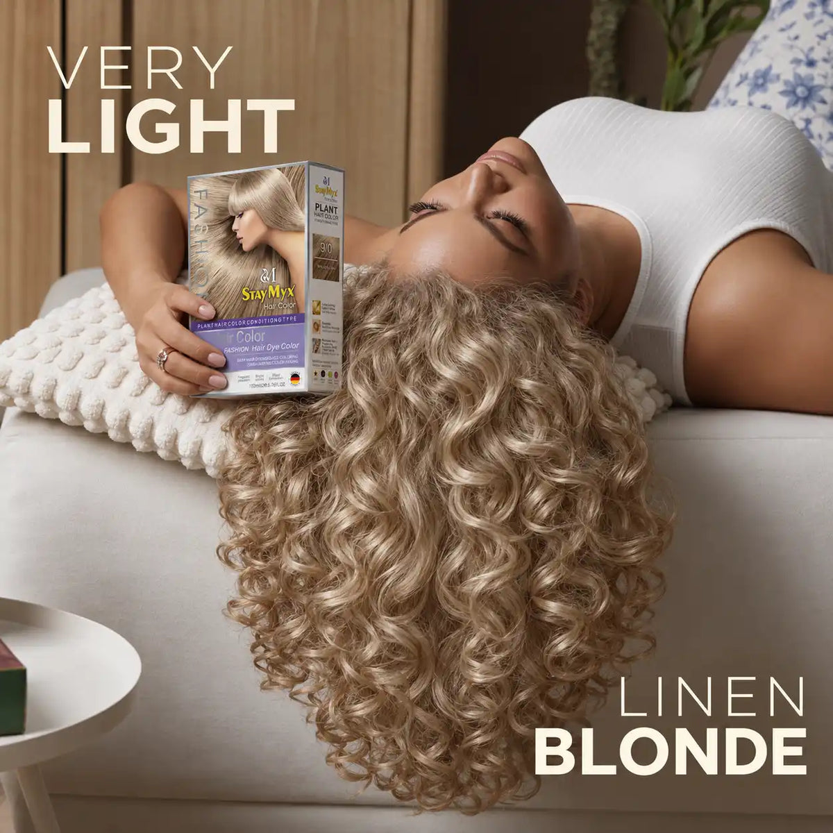 Woman with long, voluminous linen blonde curls holding StayMyx 9/0 Very Light Linen Blonde hair dye, showcasing a soft, natural-looking blonde shade.